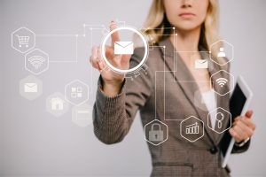 cropped view on businesswoman in suit holding digital tablet and pointing at email marketing icons