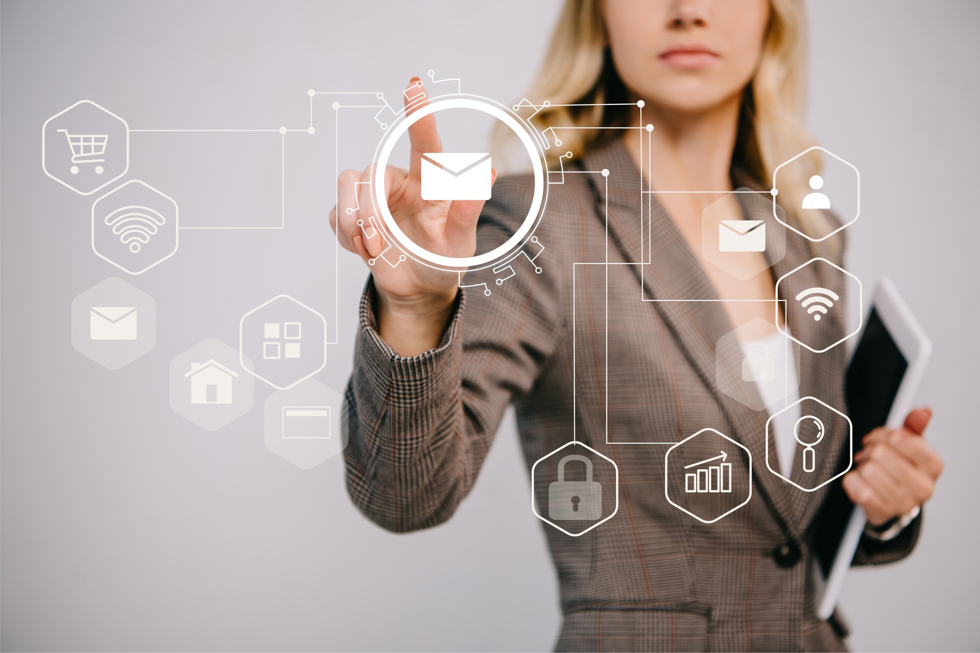 cropped view on businesswoman in suit holding digital tablet and pointing at email marketing icons